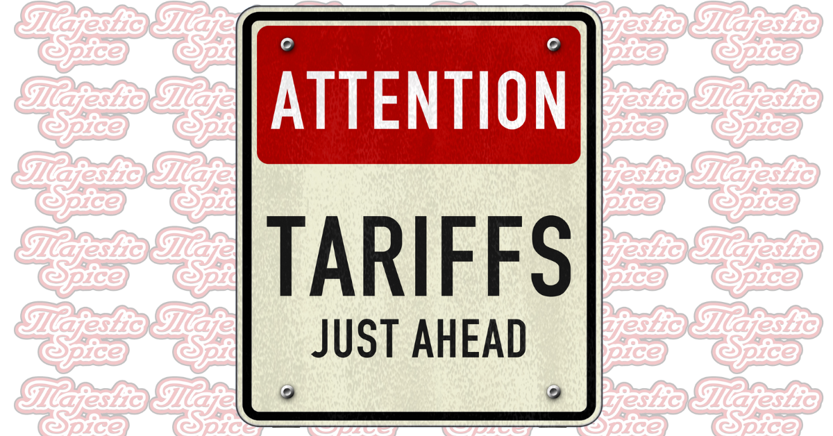 A road-style warning sign with a red header that says "ATTENTION" in white capital letters. Below it, in large black capital letters, it reads "TARIFFS JUST AHEAD." The background consists of a repeated pattern of the "Majestic Spice" logo in light pink. The sign has a slightly worn texture, giving it a vintage appearance.