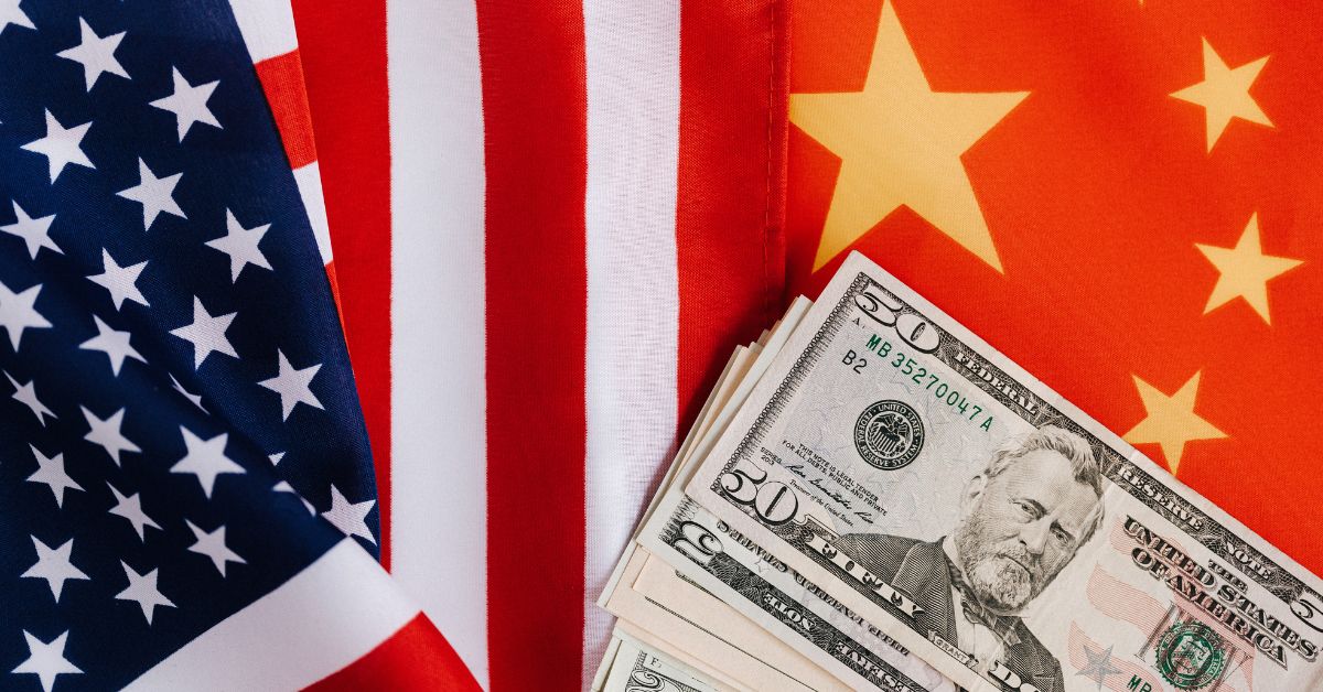 A Resurgence of Tensions: China Warns U.S. Over Trump’s Threat of 100 % Tariffs U.S. and China flags with dollar bills representing international trade and tariff impact on global spice imports and exports.